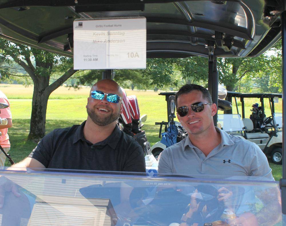 2 men in golf cart